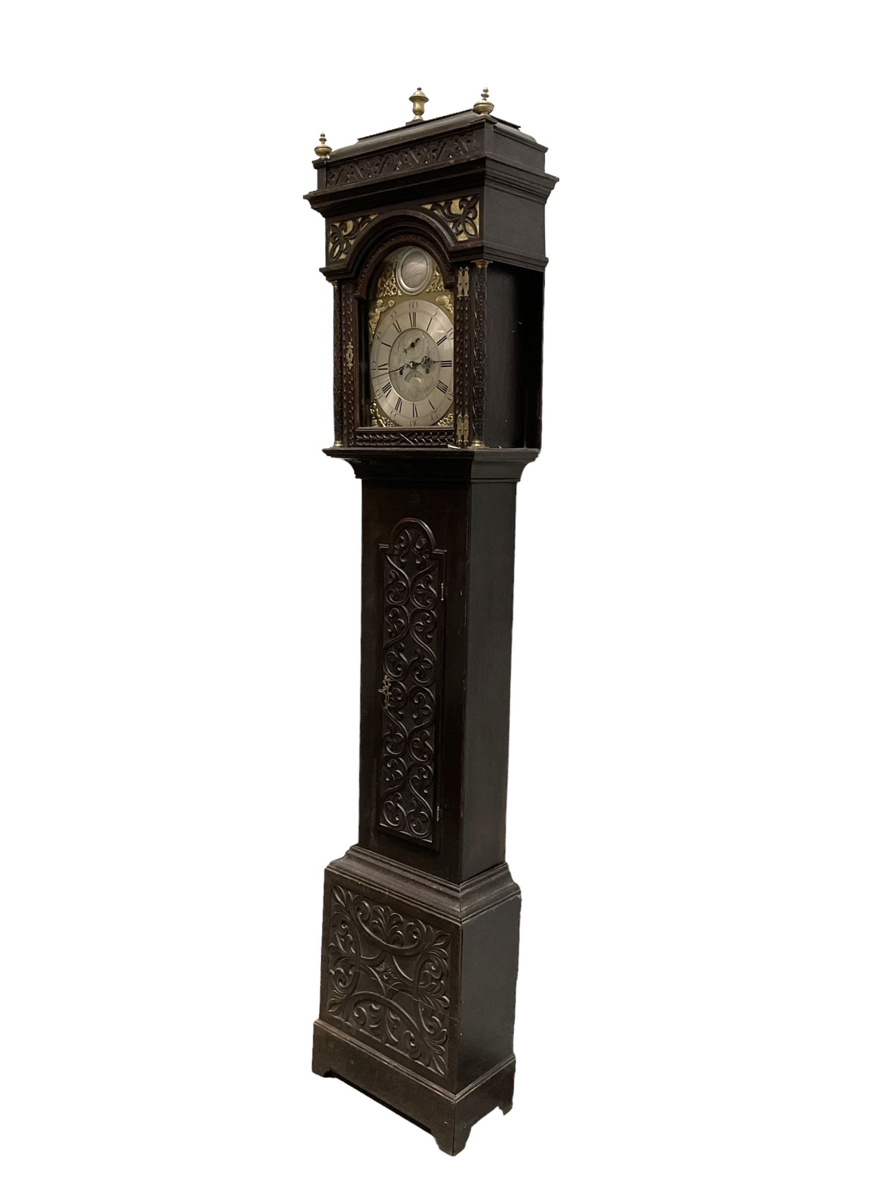 Edward Golland of Retford (Notts) - mid-18th century 8-day carved oak longcase c1760 , with a stepped caddy top and blind fret, break arch hood door flanked by carved pilasters with brass capitals,  trunk with a carved break arch toped door on a carved plinth with applied skirting and feet, brass dial with matching steel hands, silvered and engraved dial centre and chapter ring, with seconds dial and calendar aperture, four seasons spandrels and boss to the arch with makers name, four pillar rack striking movement, striking the hours on a bell. With weights and pendulum.            
Edward Golland is recorded as working in Retford during the late 18th century.