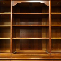 Barker & Stonehouse - large cherrywood bookcase cabinet, the moulded cornice above two glazed doors flanking an open central section, the base with three cushion drawers over four lockable panelled cupboard doors, raised on bracket feet