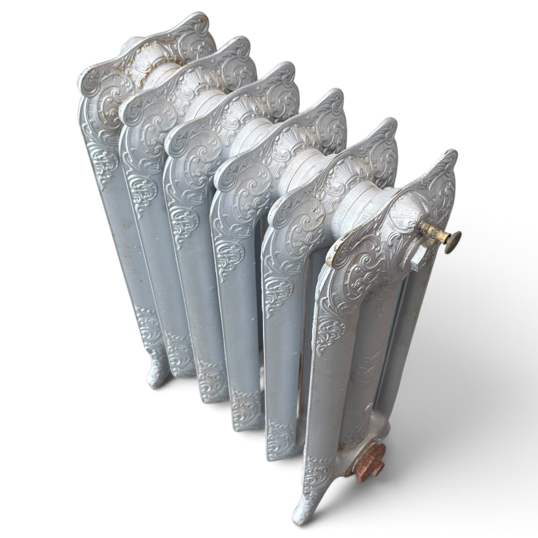 French ornate cast iron column radiator of Rococo Revival design, each section cast with scrolling foliate decoration with rocaille and cartouche motifs, with brass valve and integral bracket feet, in painted silvered finish