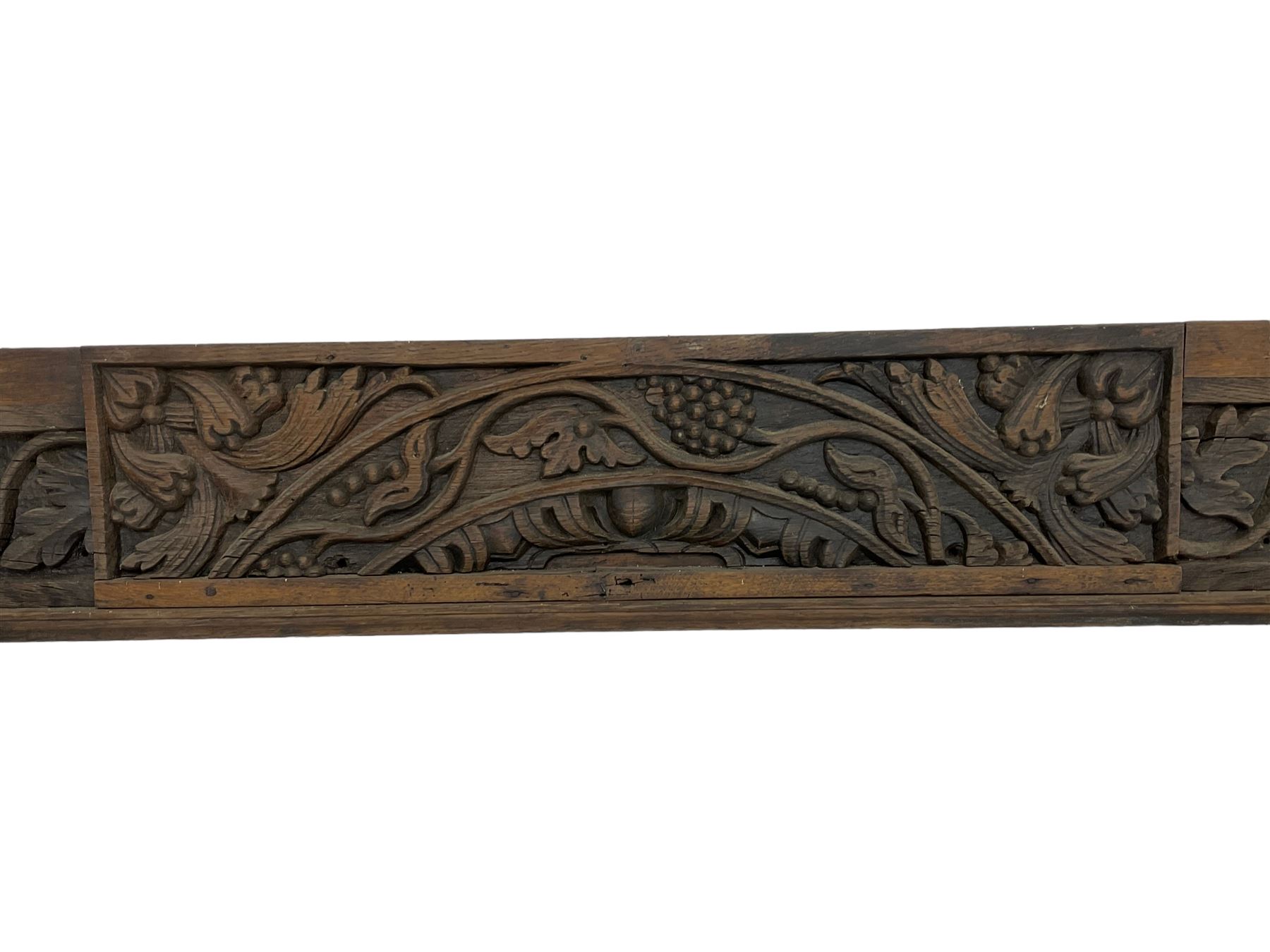 19th century Jacobean Revival oak fire surround, decorated with applied carved panels depicting foliate patterns and stylised grape vines, uprights carved with fleur-de-lis decoration