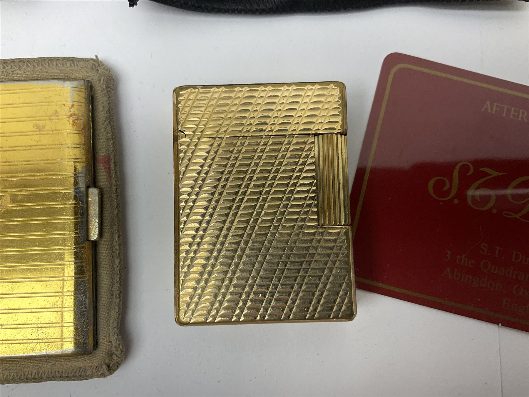 St Dupont gold plated cigarette lighter, with engine turned decoration, serial no EW1279, together with three powder compacts, including Stratton and Regent of London examples