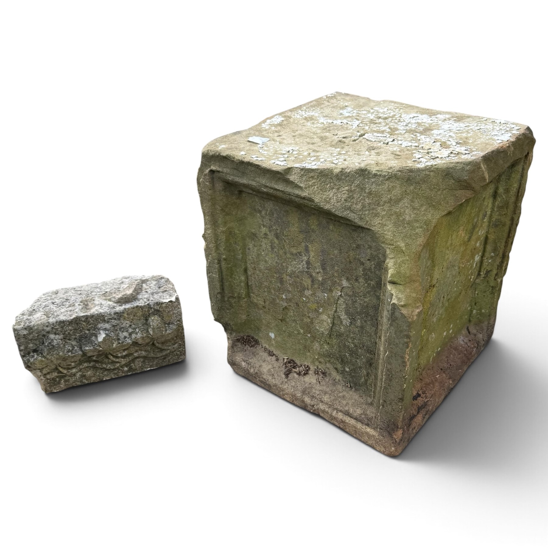 Two 18th century carved sandstone architectural elements, comprising a substantial square pedestal block with recessed panelled facias (W42cm H45cm); and a frieze fragment carved in relief with three stylised flowerheads and an undulating foliate stem (W30cm H18cm)