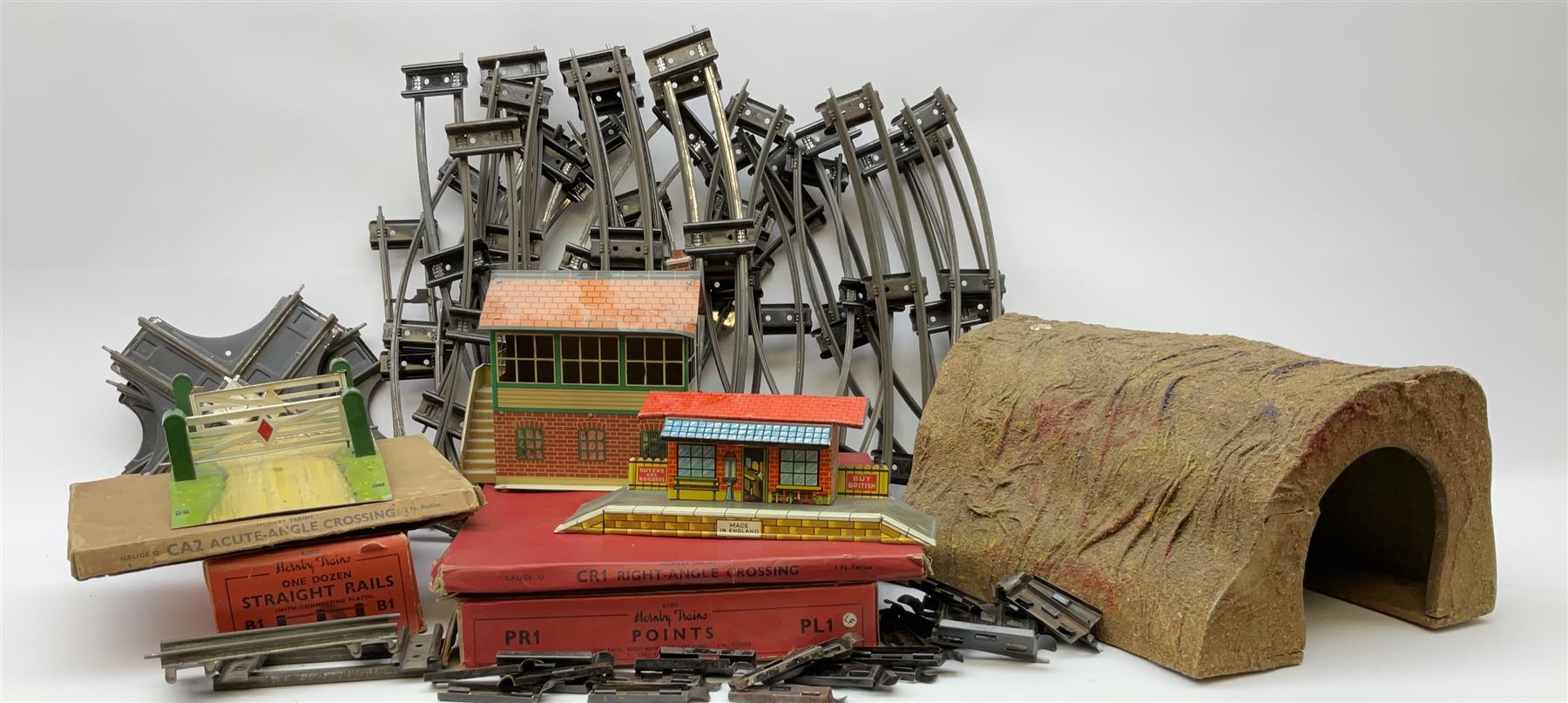 Hornby '0' gauge - layout accessories comprising PR1/PL1 Points, CR1 Right Angle Crossing and CA2 Acute Angle Crossing, all boxed; tin-plate signal box; tin-plate level crossing; textured wooden tunnel, possibly pre-WW2; and quantity of track, some boxed; together with '00' gauge tin-plate station