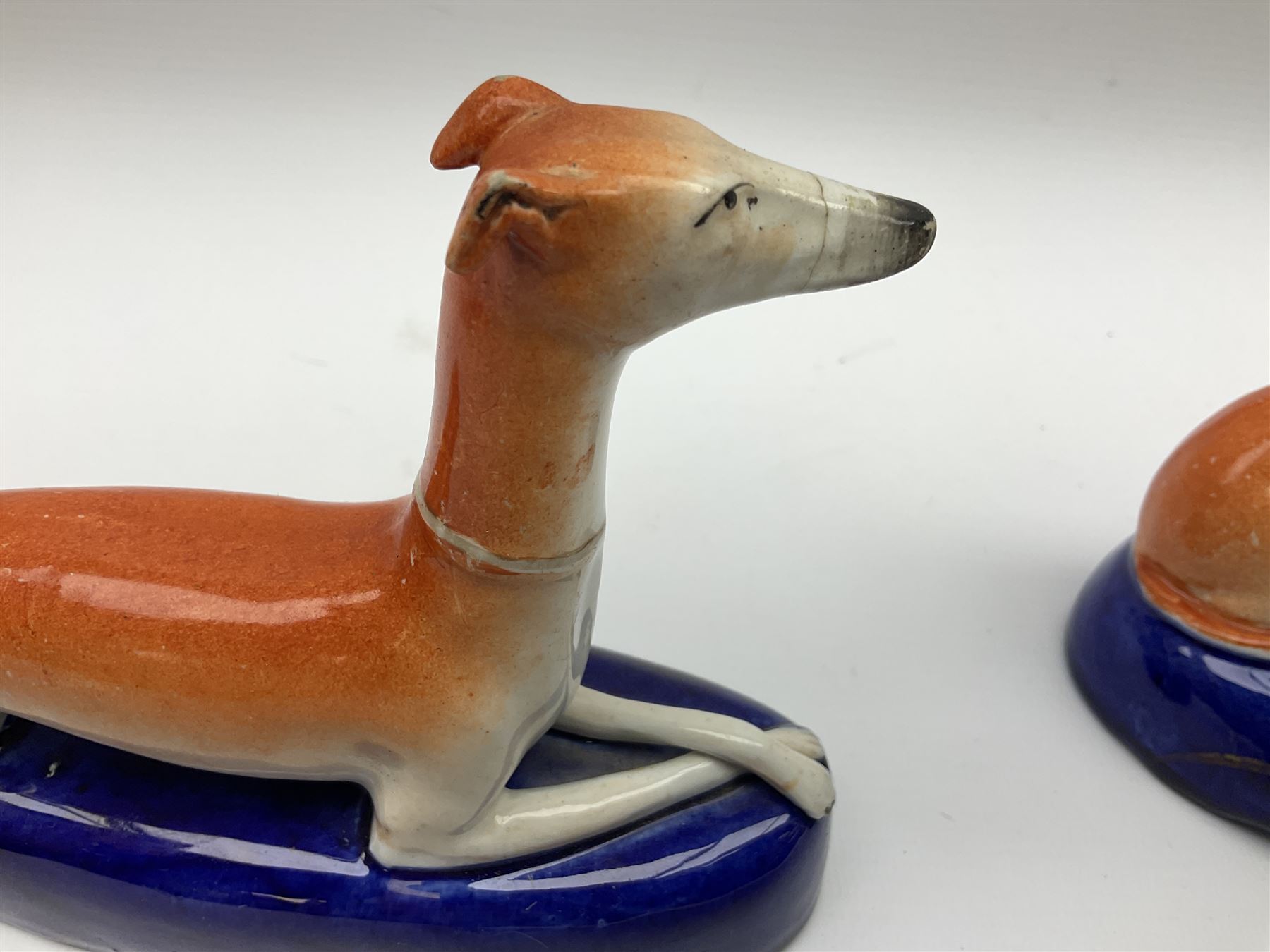 Pair of Staffordshire recumbent greyhound pen holders 