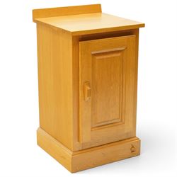 Unicornman - craftsman made oak bedside cupboard, raised back over panelled cupboard, on skirted base applied with carved unicorn signature, by Geoff Gell of Coxwold