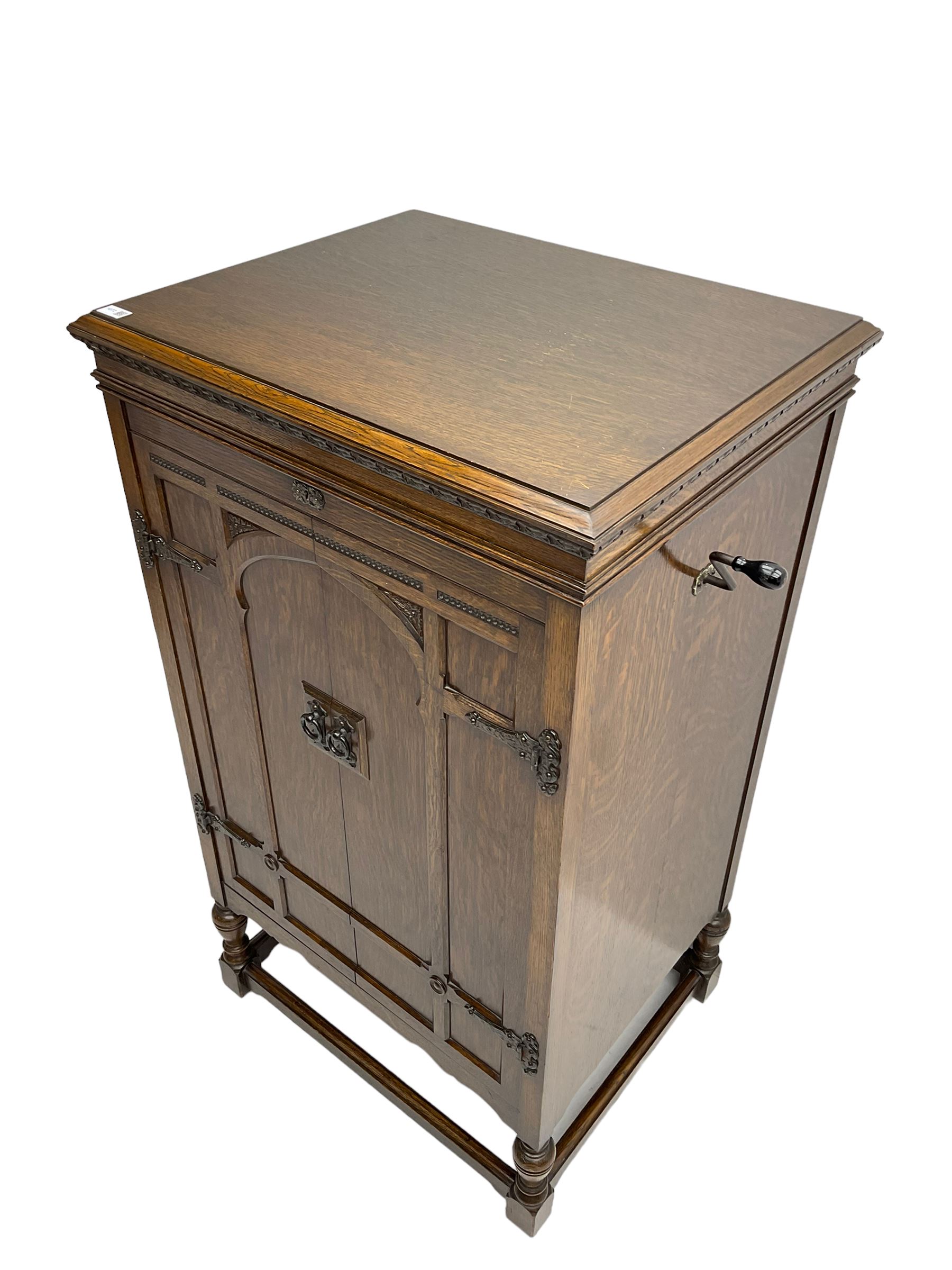 Early 20th century ‘HMV' 202 cabinet gramophone, oak cased, moulded top with foliate carved moulding hinges to reveal gramophone, two doors enclosing horn, on turned supports joined by moulded stretcher rails
