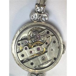 Platinum Art Deco milgrain set diamond manual wind lever wristwatch, cream enamel dial with Arabic numerals, diamond set bezel, the case spaced by two groups of three diamonds of approx 0.20 carat each, to a platinum expanding link bracelet, the first two links on each side set with diamonds, back case stamped 8942 and initialled JF with Fleur de Lys mark sitting between the letters