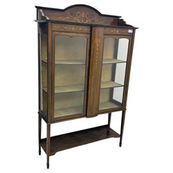 Edwardian mahogany and satinwood crossbanded display cabinet, arched pediment centred by marquetry scrollwork and ribbon decoration, twin glazed doors enclosing a lined a shelved interior, raised on square tapering supports joined by a shaped undertier with diamond parquetry inlay, terminating in spade feet