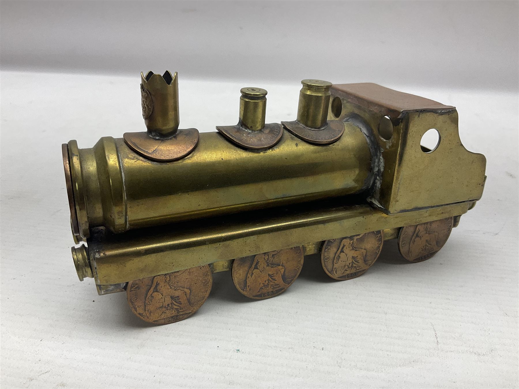 Trench Art - WWI 0-8-0 steam locomotive made from brass, copper and late Victorian pennies and half-pennies L17.5cm; WWI brass and copper tank candleholder; WWI brass shell case two-handled vase inscribed 'RFA France 1914-17'; and an unrelated brass plant holder (4)