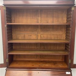 Early 19th century figured mahogany bureau bookcase, projecting splay moulded cornice over three adjustable shelves enclosed by two glazed doors, fall front revealing pigeonholes, cupboard and drawers, pull-out strays with scroll carved terminals, double cupboard with two panelled doors, on turned feet 