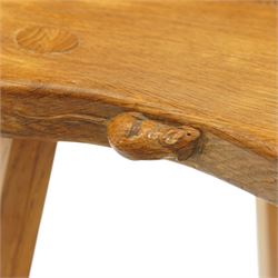 Mouseman - oak three-legged milking stool, dished kidney-shaped seat, raised on three octagonal splayed supports, with carved mouse signature, by the workshop of Robert Thompson of Kilburn