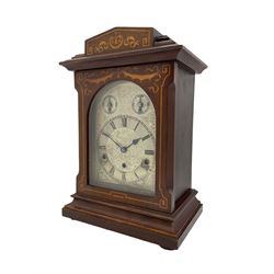  An Edwardian c1905 Westminster chiming mantle clock in a mahogany Sheraton style case with inlay and stringing, with a silvered one-piece dial with etched decoration, Roman numerals and minute track, with subsidiary strike/ silent dial and pendulum regulation dial, eight-day German three train movement striking the quarters on 5 gong rods. With pendulum and key.


.

