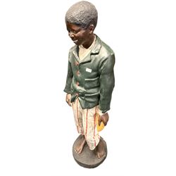 Plaster cast figure of a young boy holding a polishing rag, on circular base 
