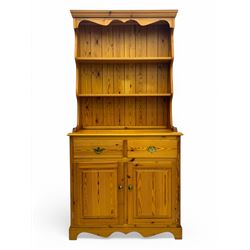 Victorian design pine dresser, projecting moulded cornice over scalloped frieze and two open shelves, base fitted with two drawers over double cupboard, on shaped plinth base