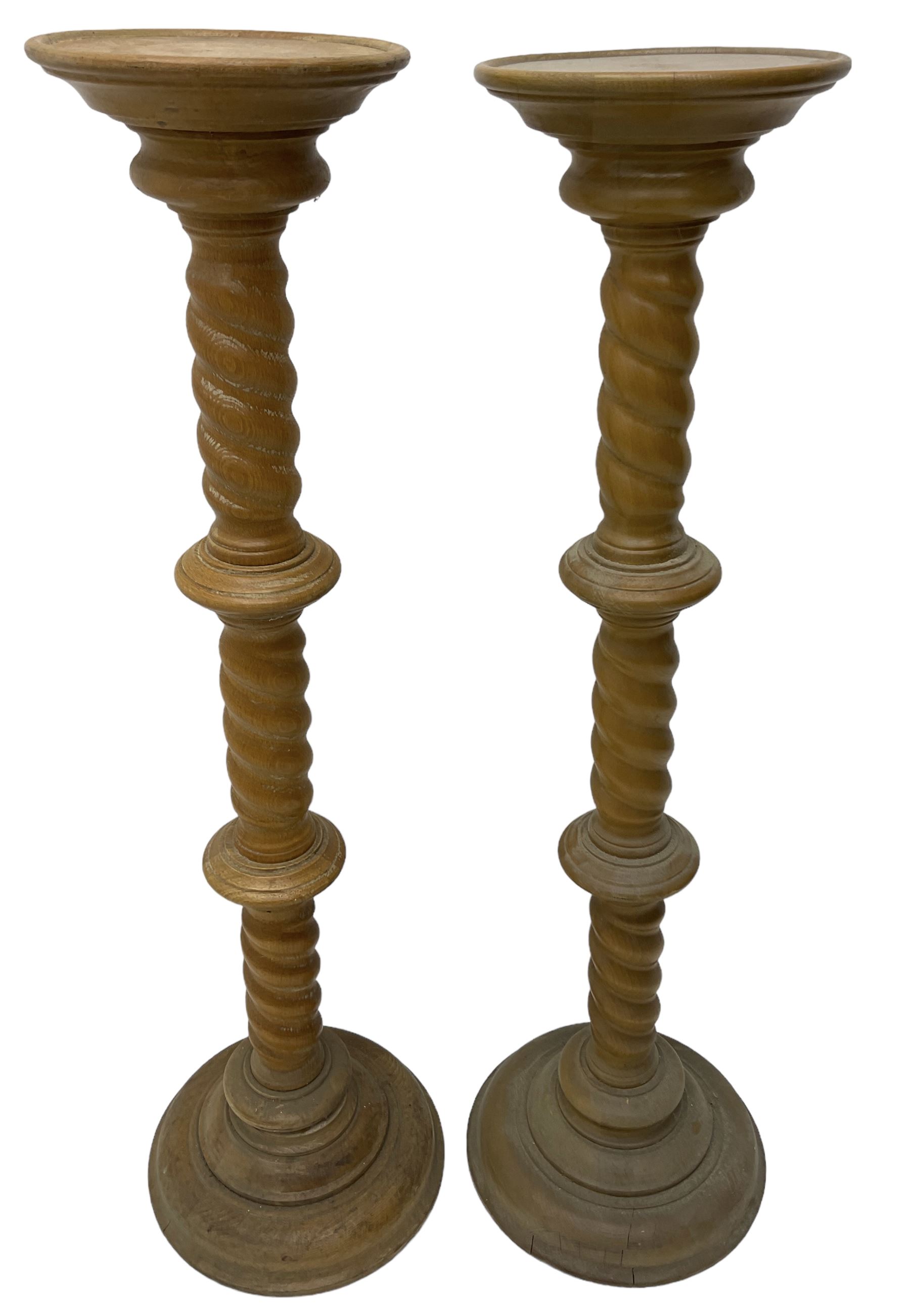 Pair of Victorian design light oak torcheres or jardinieres, circular top with raised lip over a spiral turned column terminating in circular turned plinth base