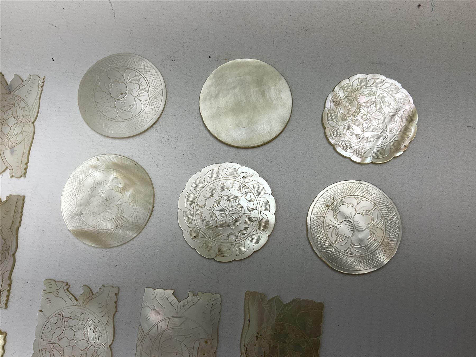 Collection of fifty two Chinese mother of pearl gaming counters or tokens, of various size and form including rectangular, circular and fish shaped examples, various decoration including floral motifs, largest rectangular examples L4cm