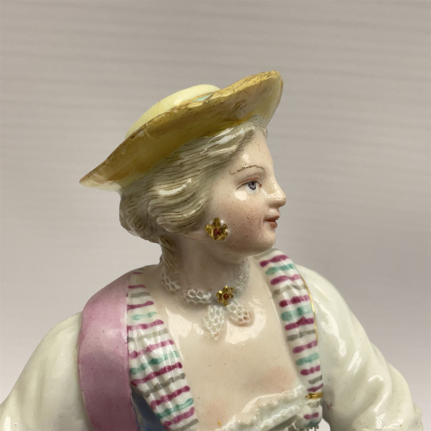Pair of late 19th/early 20th Century Meissen figures, modelled as flower sellers, after the original by Michel Victor Acier, she holding basket of flowers, he holding flowers in his hat, each with underglaze cross swords mark beneath, tallest H16.5cm