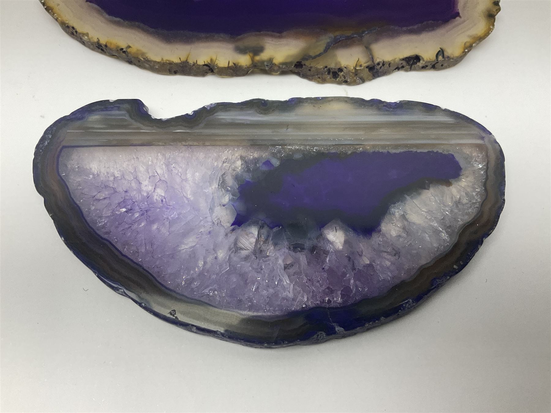 Four purple agate slices of various sizes, polished with rough edges