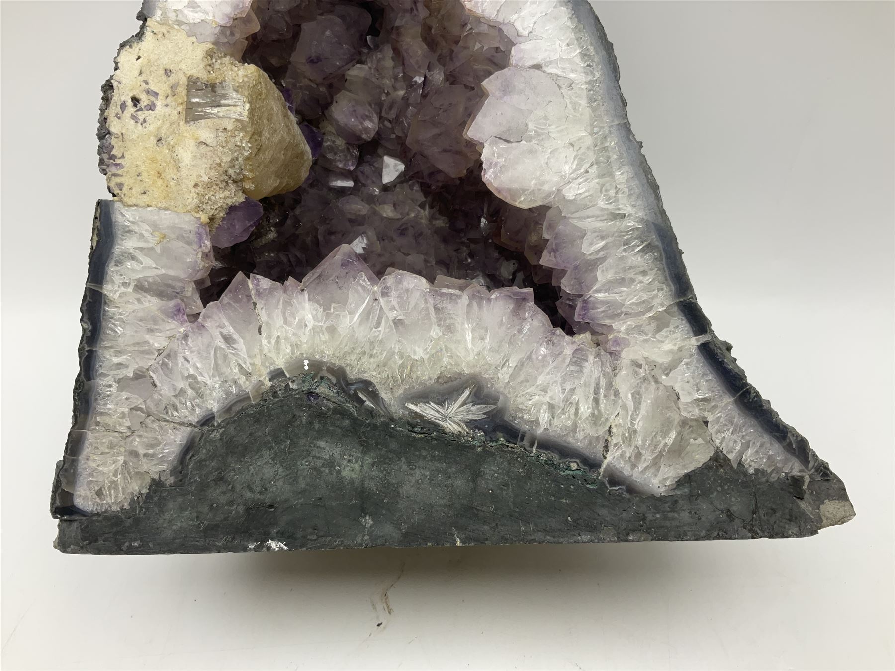 Amethyst crystal ‘cathedral’ geode, free standing with flat base and prepared outer surface, with well-defined crystals of various sizes within the cavern, H39, L32cm