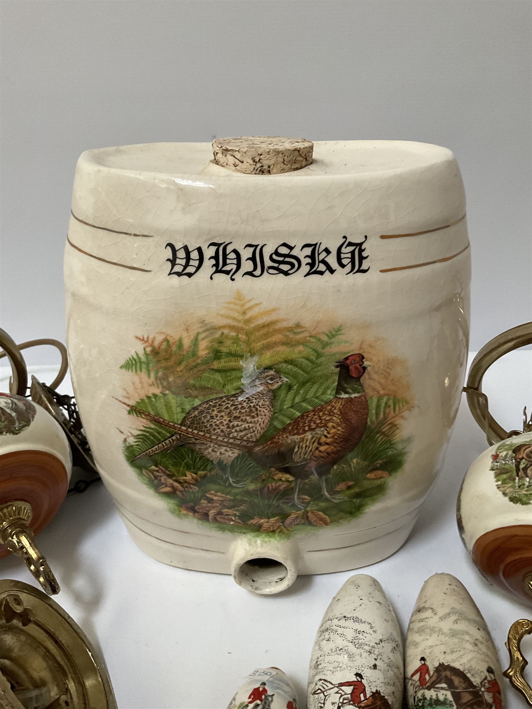 Ceramic hanging light fittings decorated with fox hunting scenes with brass fixtures, ceramic beer pulls decorated with hunting scenes and ceramic whisky barrel decorated with a pheasant