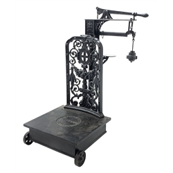 19th century platform scales by Parnall & Sons. Bristol, black painted cast iron, raised back decorated with foliage scrolls and fruit garland, H128cm