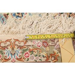 Fine Persian silk inlaid ivory and rose ground Tabriz rug, the busy field decorated with a central foliate pole medallion surrounded by scrolling foliage with trailing flowerheads and bouquets, the multiple guard lines filled with repeating scrolling palmettes and interlocking floral motifs