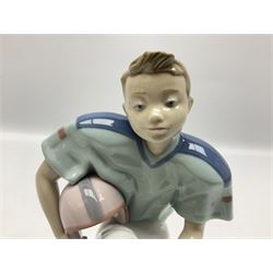 Lladro figure, Football Player, modelled as a young boy playing American football in kneeling position, sculpted by Joan Coderch, with original box, no 6107, year issued 1994, year retired 1998, H18cm