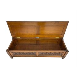 Early 20th century oak ‘bay window’ shaped blanket chest or coffer, hinged top, the front with two lunette carved panels flanked by fluted uprights, on turned feet
