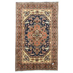 Persian ivory and peach ground, overall geometric design, the field with central star medallion surround stylised leaf motifs, guarded geometric design border