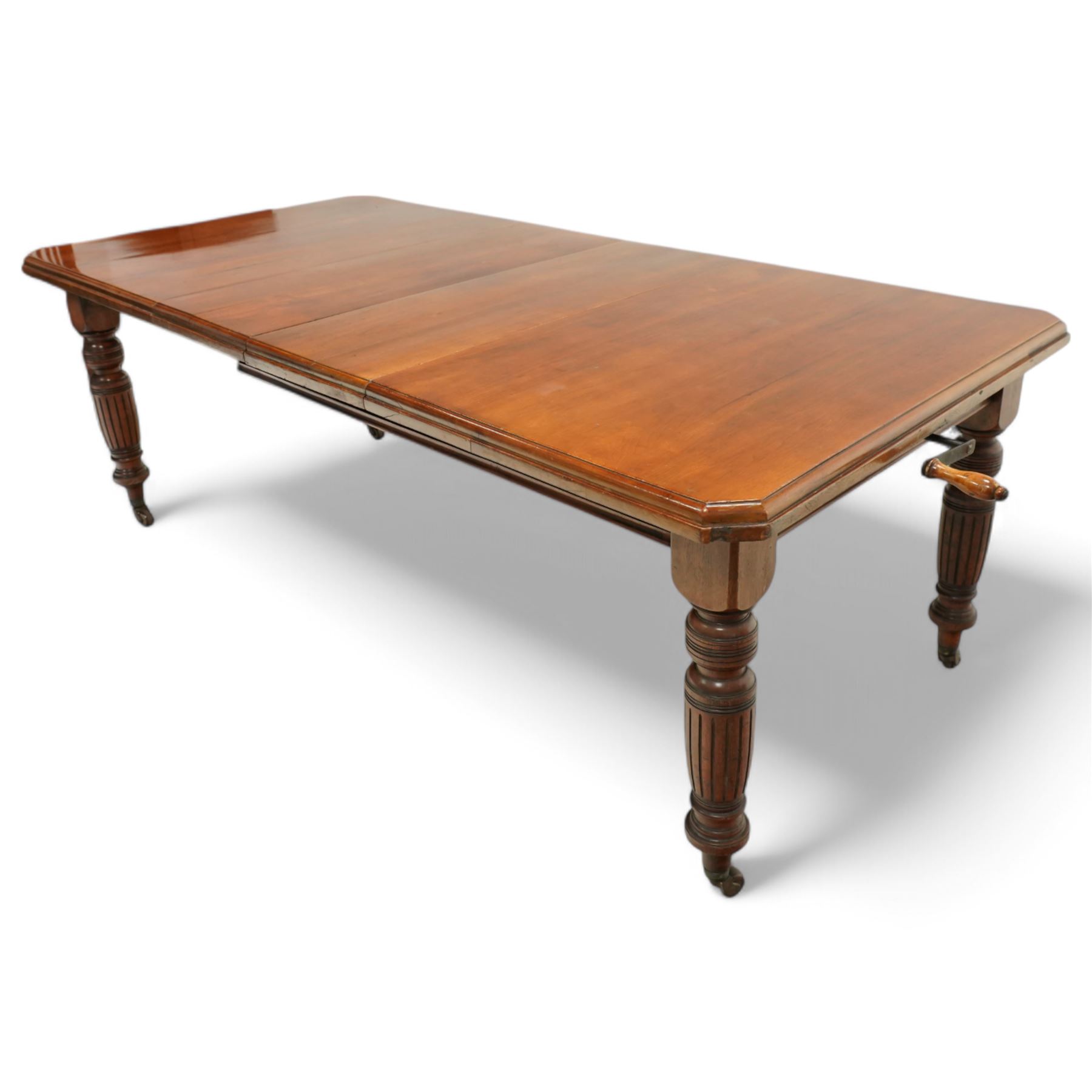 Late Victorian mahogany extending dining table with two leaves, moulded chamfered edge above, turned and reeded legs and ceramic castors, winding handle included, 205cm extended, 132cm closed, 102cm wide, 73cm high