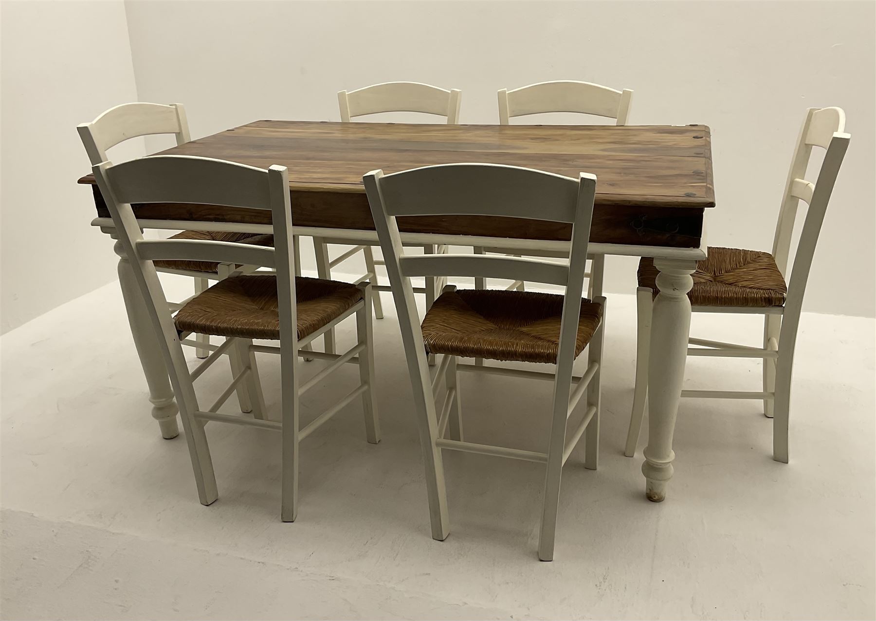 Mexican painted and polished pine rectangular dining table, raised on turned supports (W150cm, D90cm, H76cm), together with six chairs, rush seat raised on square supports (W40cm)