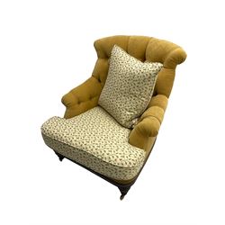 Victorian style armchair, upholstered in buttoned fabric with contrasting foliate pattern seat and scatter cushion, on turned front feet with castors