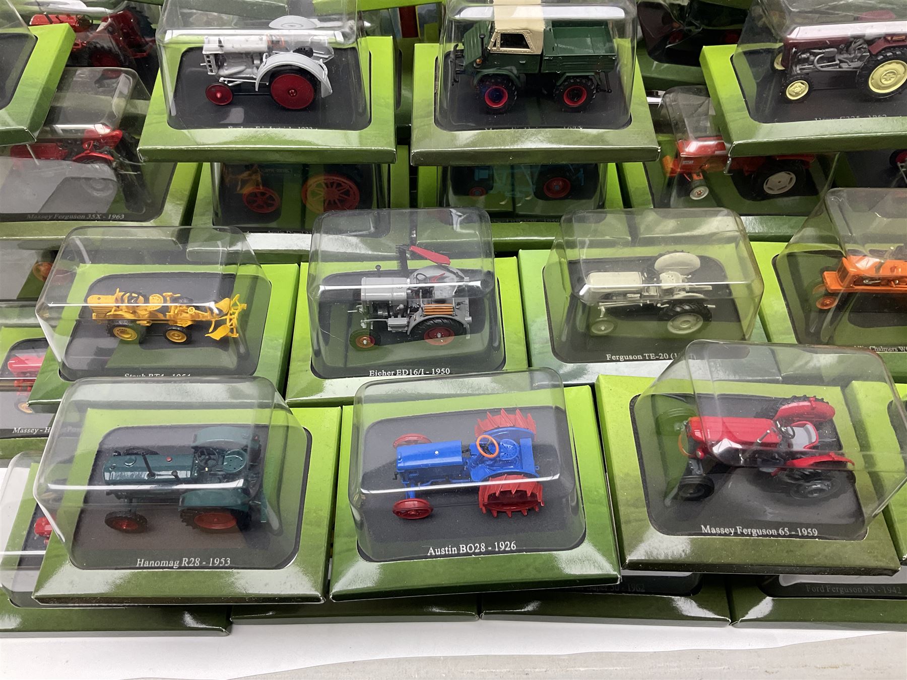 Eighteen issues of Tractors and The World of Farming magazine, together with sixty diecast tractors, all in original packaging, in three boxes 