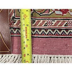 Finely knotted Persian Qom silk rug, overall pink ground with ivory field, the field with central cusped medallion profusely decorated with interlacing foliate and stylised flower heads, multiple band boarder, the main band decorated with a series of stylised motifs and trailing foliage, the outer guard with signature panel 