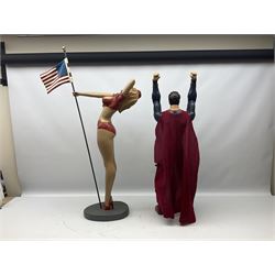 Composite Superman with cape, together with a composite female statue holding the American flag, tallest example H103cm