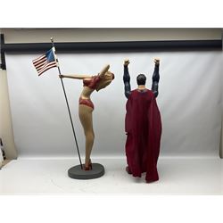 Composite Superman with cape, together with a composite female statue holding the American flag, tallest example H103cm
