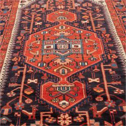 North West Persian runner, the indigo field centred by a red elongated hexagonal medallion with pendant motifs, surrounded by angular flowering stems, ivory stepped floral spandrels, enclosed by an indigo palmette border and red floral guard bands