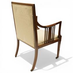 Arts & Crafts period inlaid mahogany framed armchair, swept arms with satinwood-strung supports over back and sprung seat upholstered in cream foliate damask fabric, on square tapering supports with castors