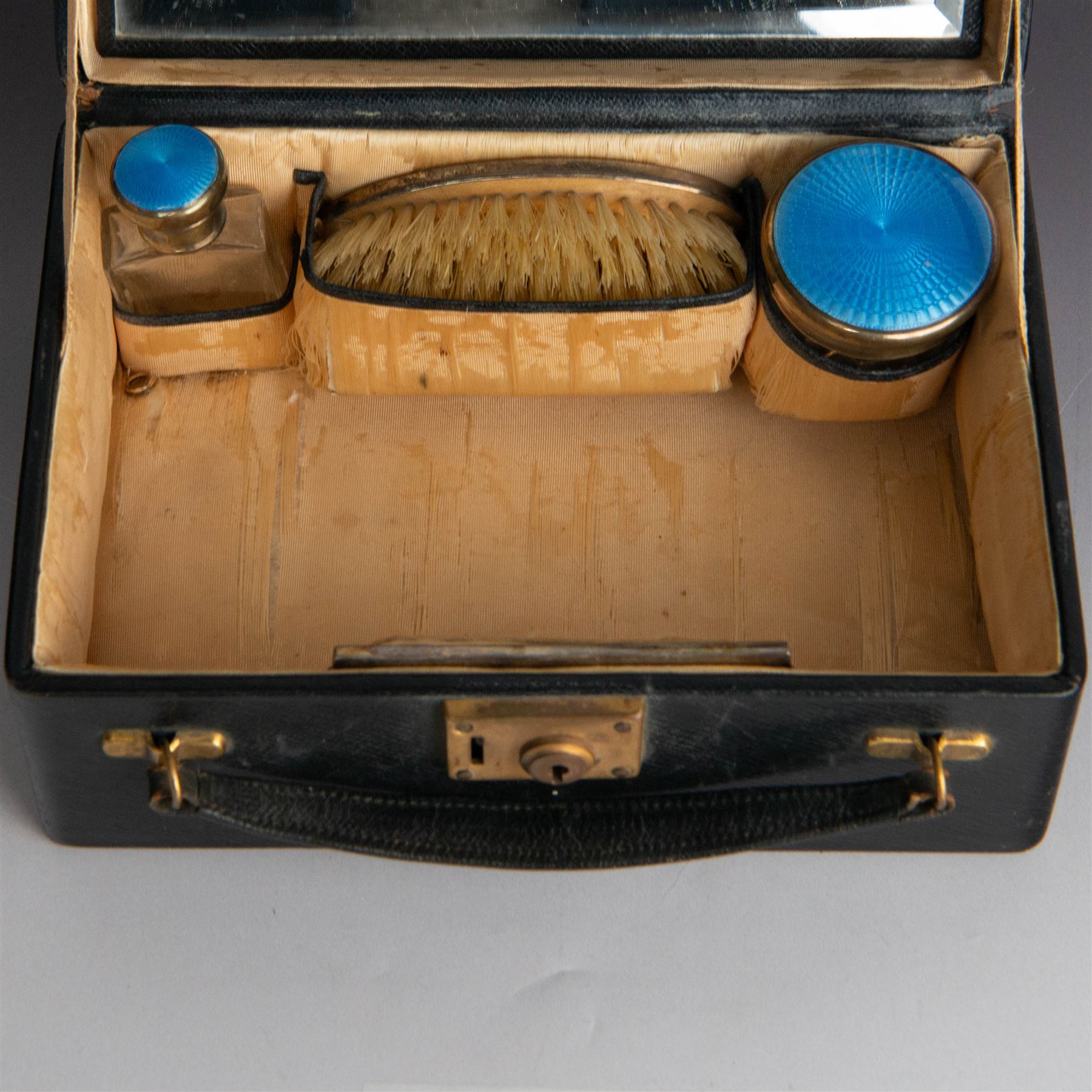 1920s silver mounted blue guilloche enamel travelling dressing table set, comprising hairbrush, comb, bottle and jar, hallmarked RWF Ltd, Birmingham 1927, contained withing tooled leather fitted case with bevelled mirror to interior