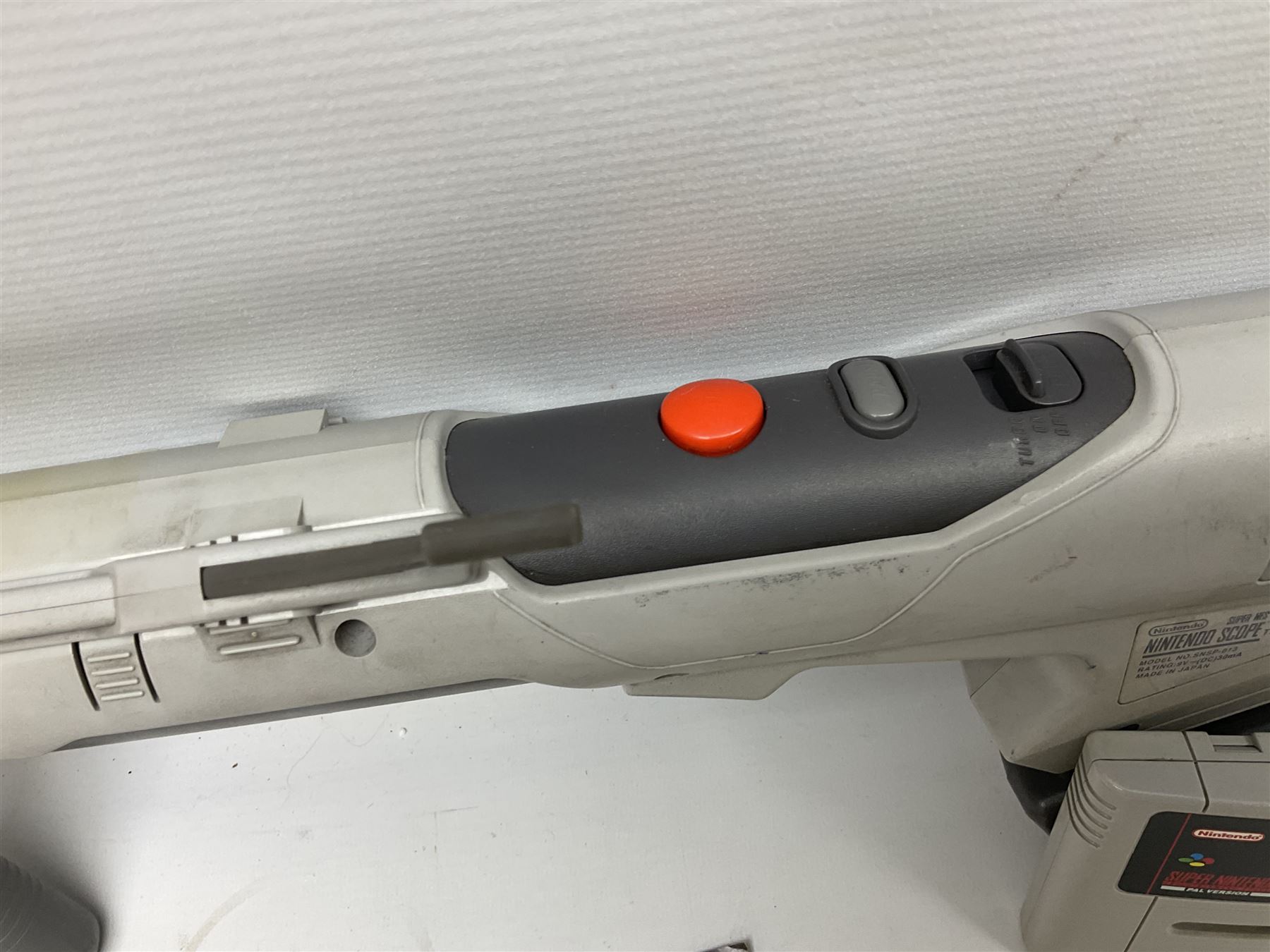 Two Super Nintendo Entertainment System (PAL) controllers, accessories and games. Super NES Game Commander with original box and instruction booklet, Super NES Nintendo Scope (1992) transmitter gun, receiver, Super NES Nintendo Scope 6 game with original instruction booklets. Further games to include ‘The Legend of Zelda a Link to the Past’, ‘Super Mario World’, ‘Super Mario Kart’, ‘The Lawnmower Man’, and ‘Exhaust Heat’, all with original instruction booklets. ‘PowerMonger’ and Disney’s ‘Aladdin’ game cartridges only 