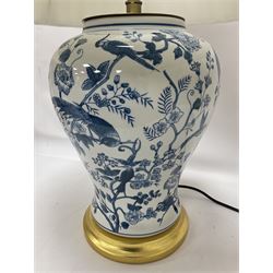 Pair of blue and white table lamps, each of baluster form, decorated with exotic birds, raised upon circular gilt bases, excluding fittings H39cm