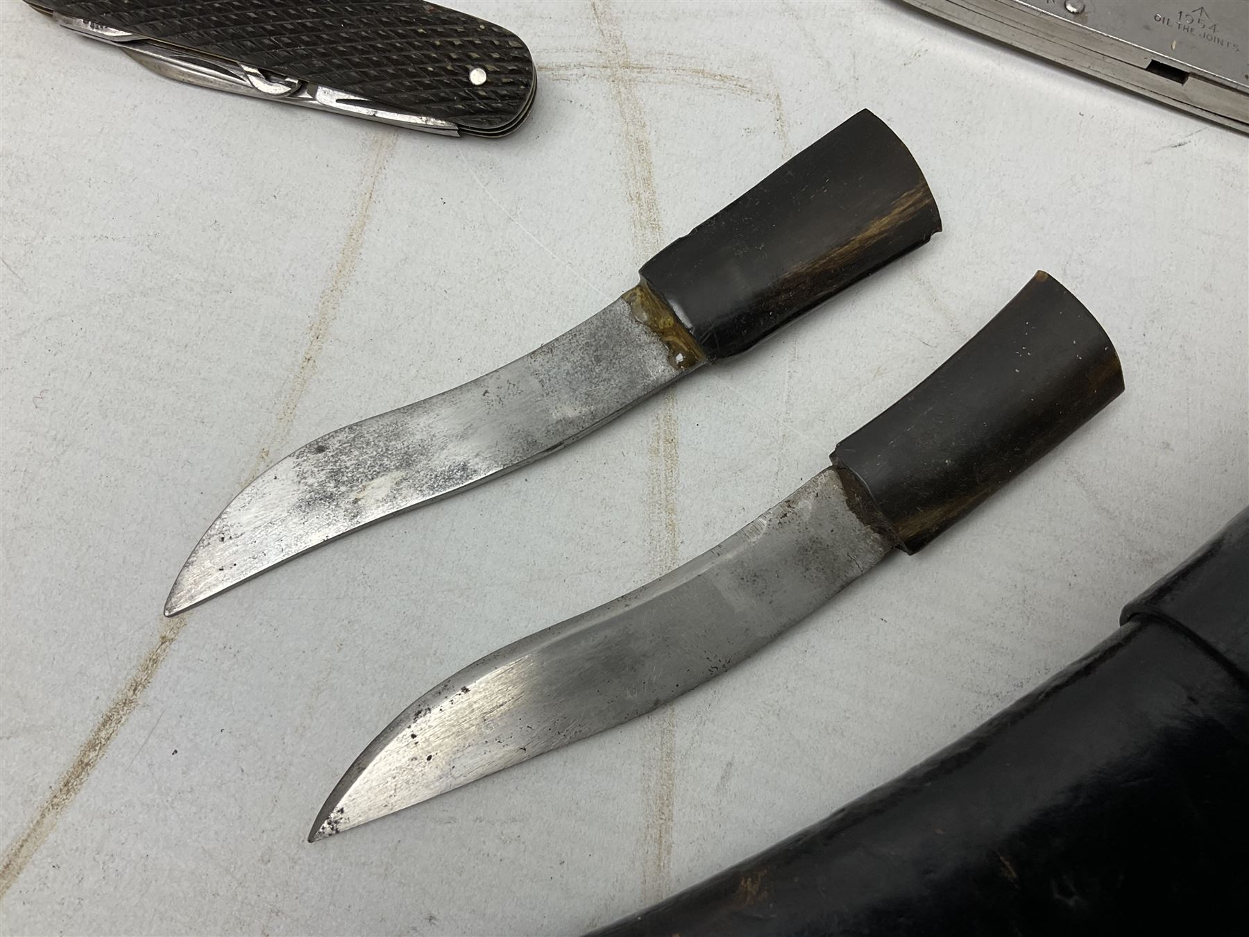 WW2 Gurkha Kukri knife with 34cm curving steel blade and horn handle; in leather covered scabbard with dual belt loops and two horn handled skinning knives L47cm overall; and collection of fourteen military and other folding and pocket knives including WW2 British Army clasp jacknife, J.H. Thompson C.C.1286 army knife dated 1954, Brookes & Crookes multiblade pocket knife etc (15)