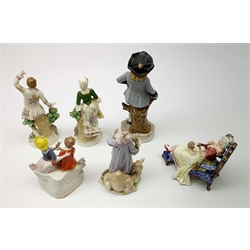 A pair of Sitzendorf figures, modelled as a male and female figure in eighteenth century dress with sheep beside feet, each upon gilt detailed circular base, each with printed mark beneath, tallest H18.5cm, together with a Volkstedt figure modelled as a Eastern female figure with camel seated at her feet, with printed mark beneath, a Sitzendorf figure of a young male figure, a figure modelled as a seated female playing the lute, with dog seated upon her lap, and a figure group marked foreign. (6). 