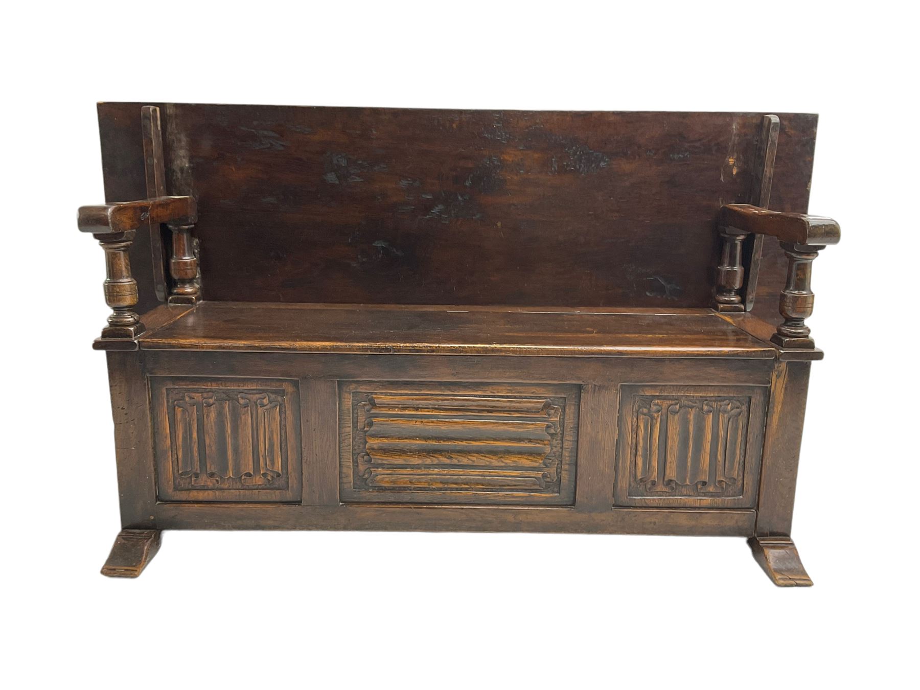 Jacobean design oak Monks bench, the front with carved linenfold panels, hinged metaphoric table back, hinged box seat compartment, on sledge feet