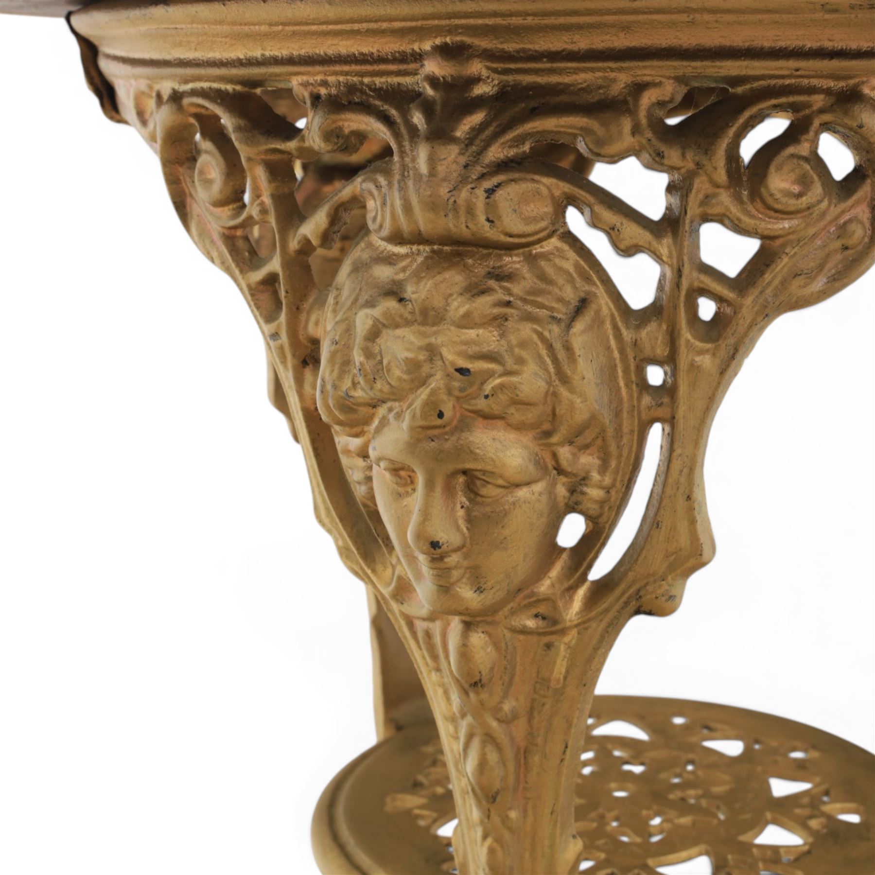 Britannia style cast iron pub table and pair of stools, moulded circular top raised on a gilt painted frame, featuring masks and acanthus detailing united by an under tier, the stools with red floral design (Stools diameter 34cm, height 47cm) 