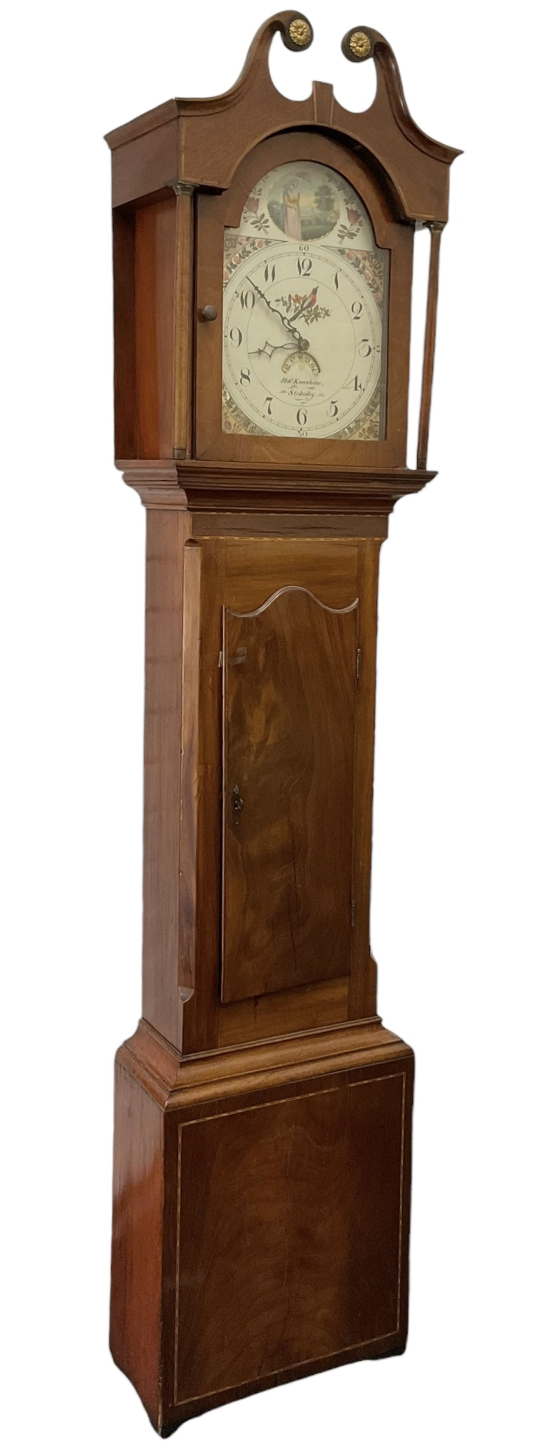 Robert Kneeshaw of Stokesley - 19th century 30 hour mahogany cased longcase clock c1820. with a swans necked pediment and brass paterie, break arch hood door with plain pilasters, inlaid trunk with canted corners, inlay and a wavy topped door, on a rectangular plinth with a shaped base, painted dial with floral spandrels and a depiction of a lady walking in the countryside, with Arabic numerals, non-matching steel hands, calendar aperture and an image of a bird of paradise to the centre, chain driven countwheel striking movement, with weight and pendulum.  