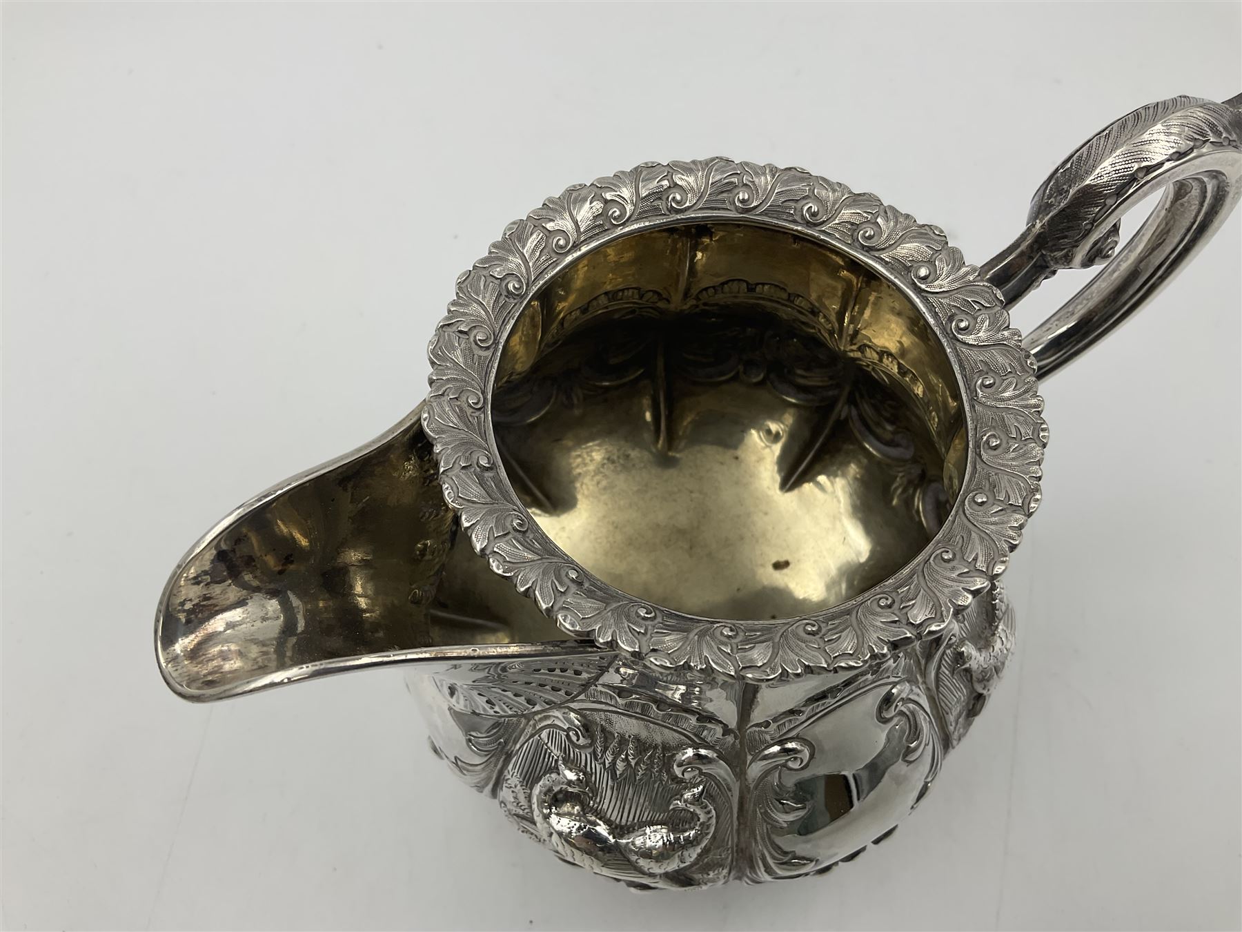 Victorian silver three piece tea service, comprising teapot, twin handled open sucrier, and milk jug, each of bellied form with acanthus capped scroll handles, the sides embossed with alternating scroll edged vacant panels and panels containing a pair of birds, upon four palmette feet, the teapot with ivory insulators to handle, and bird finial to the hinged domed cover, hallmarked William Hunter & Son, London 1861, teapot H19cm, including handles sucrier H13.5cm, including handle milk jug H12cm

This item has been registered for sale under Section 10 of the APHA Ivory Act