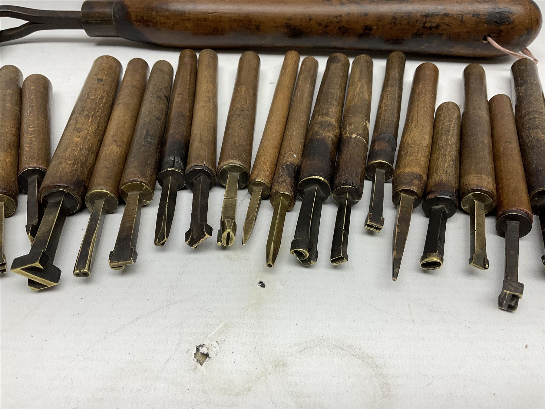 Thirty-one bookbinder's brass number and letter stamps, predominantly with beech handles, together with a bookbinder' decorative fillet roll, with brass triple line wheel stamped E. Menuel London, with wood handle, and two ink blotters