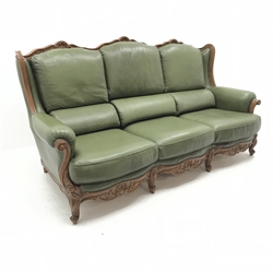 French walnut framed three seat sofa, shaped shell carved cresting rail, serpentine seats, upholstered in a studded green leather (W200cm) and pair matching armchairs (W90cm) and footstool