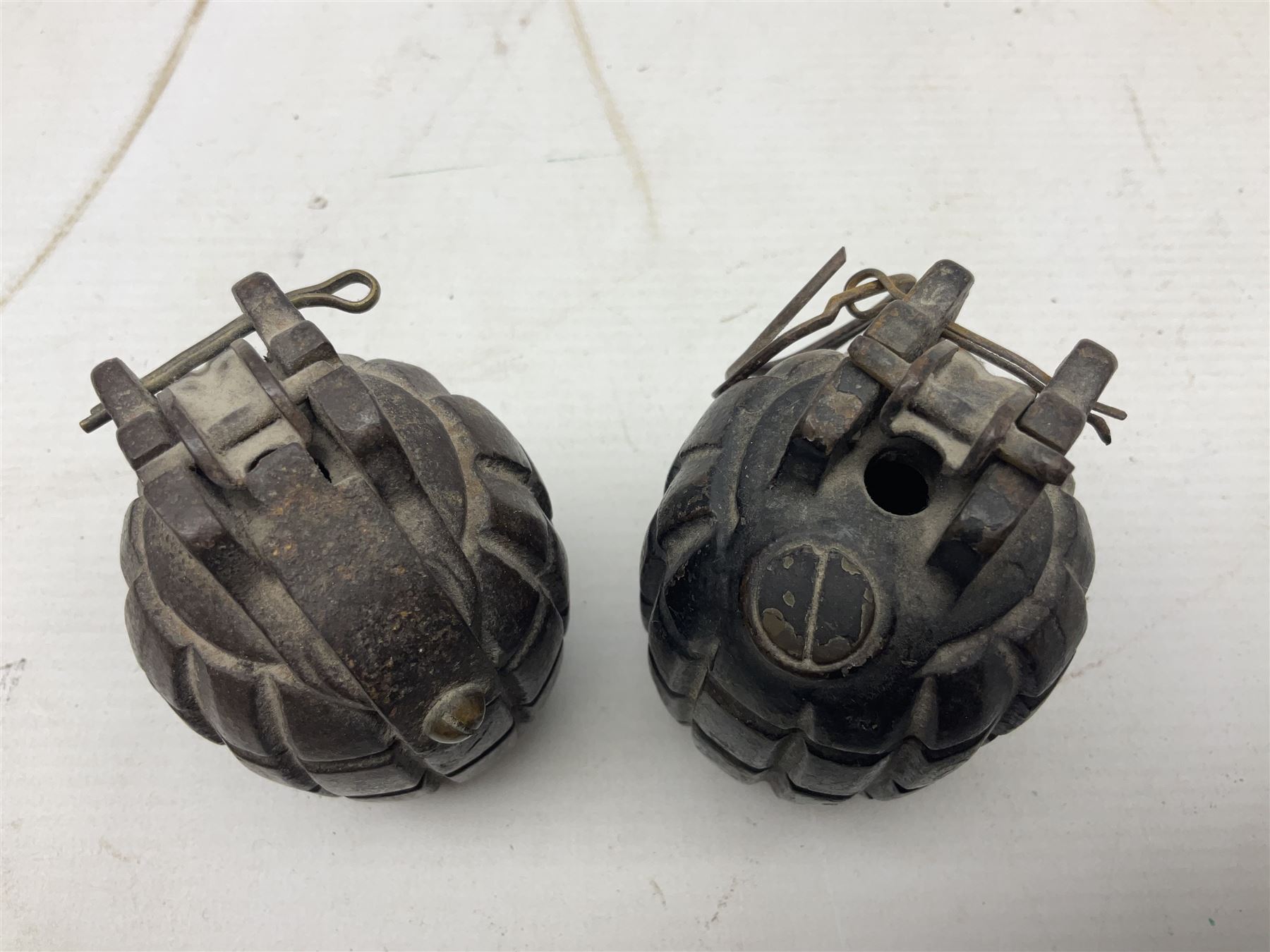 Two inert WW2 Mills Bomb (pineapple) hand grenades; one adapted as a money box with coin slit to the side and later cap H9.5cm (2)